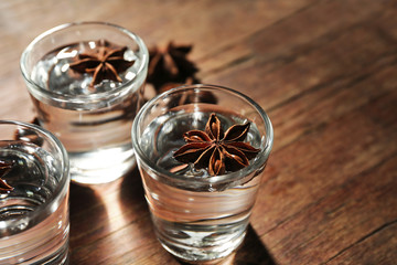 Wall Mural - Vodka with anise on wooden background