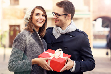 Wall Mural - Young couple with big present in the city