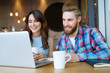 © baranq - Couple with laptop spending time at coffee shop