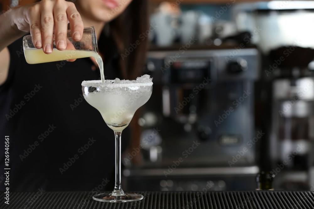 Woman hands making cocktail on bar counter