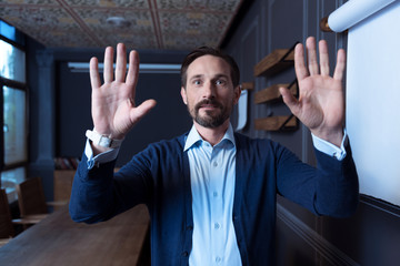 Wall Mural - Handsome delighted man pressing hands to the virtual panel