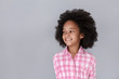 © dream_stock - Portrait of cheerful little girl looking away and smiling while standing against grey background
