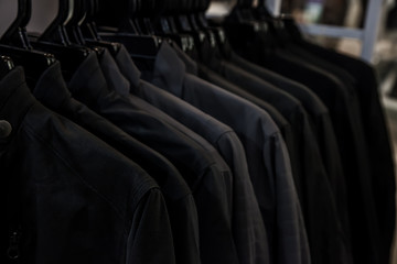 Wall Mural - Black shirt hanging on a rack in the store. Fashion and garment