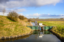 Ditch With A Small Weir In A Dutch Polder Area