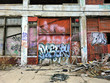 Urban ghetto building exterior with graffiti and debris