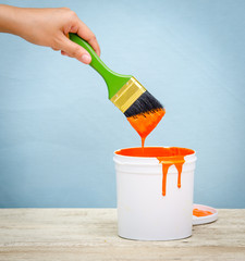 White plastic bucket with red color paint on wood,