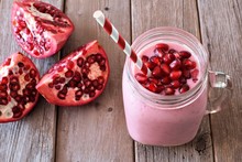 Pomegranate Raspberry Smoothie In A Jar Glass With Pomegranate Pieces, Scene Rustic Wood