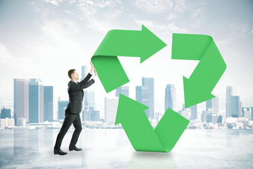 Poster - Businessman pushing recycling symbol on city background. 3D Rendering