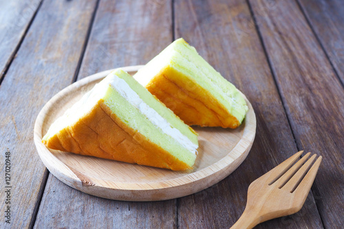 Fotografie, Obraz Close up of pandan and coconut chiffon cake on a wooden plate.