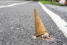 Ice Cream On The Ground. (selective Focus) , Ice Cream Cone Dropped On The Concrete Floor And Melting. , Chocolate Ice Cream Cones Dropped Melt On Ground