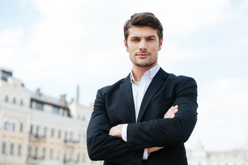 Sticker - Businessman standing with arms crossed outdoors