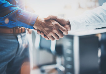 Close up view of business partnership handshake concept.Photo  two businessman handshaking process.Successful deal after great meeting.Horizontal,flare effect, blurred background.