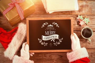 Poster - Composite image of santa claus holding a slate with merry christ