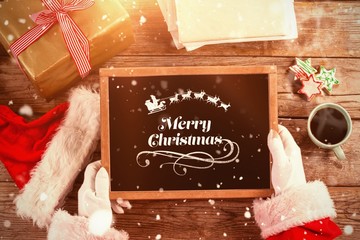 Poster - Composite image of santa claus holding a slate with merry christ