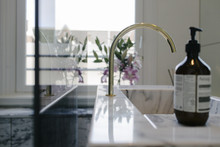 Detail Of A Modern, Stylish Bathroom With A Tap And Soap And Flowers