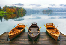 Three Boats Moored On Bled Lake At Foggy Autumn Day