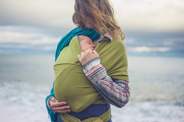 Wall Mural - Mother with baby in sling by the sea