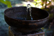Vintage bronze drinking fountain on a stone basement outdoors, closeup