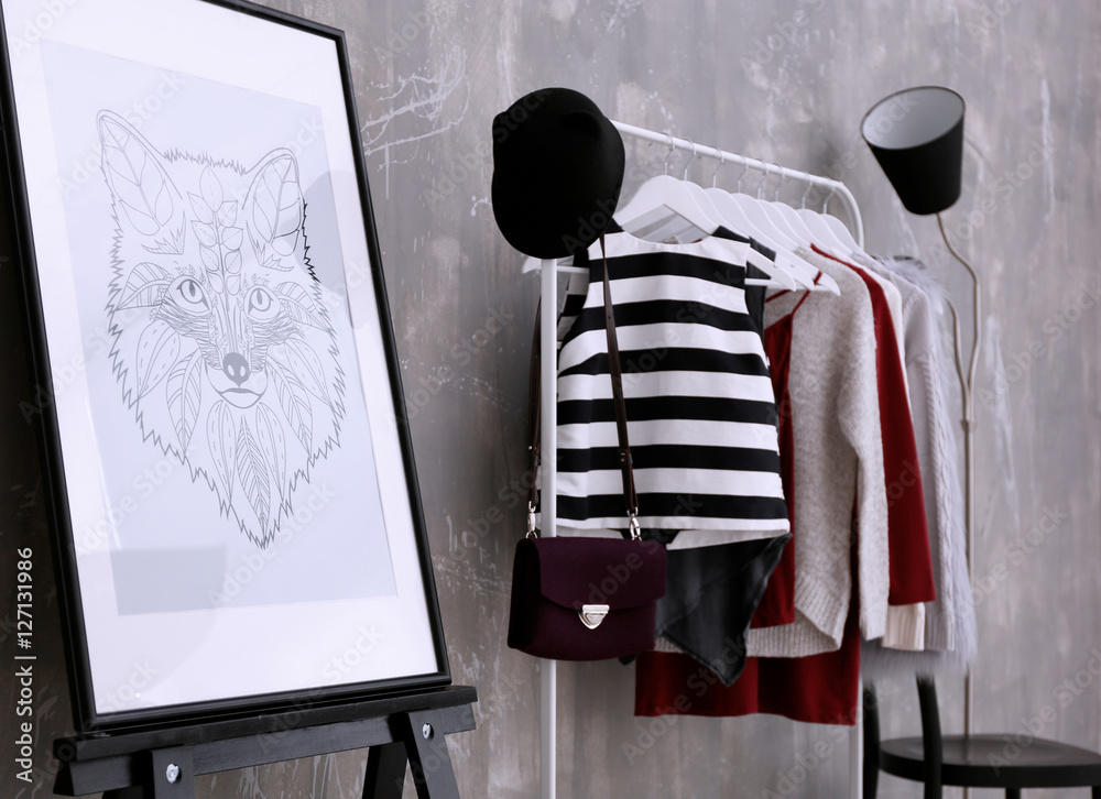 Fashionable clothes hanging on rack at modern dressing room