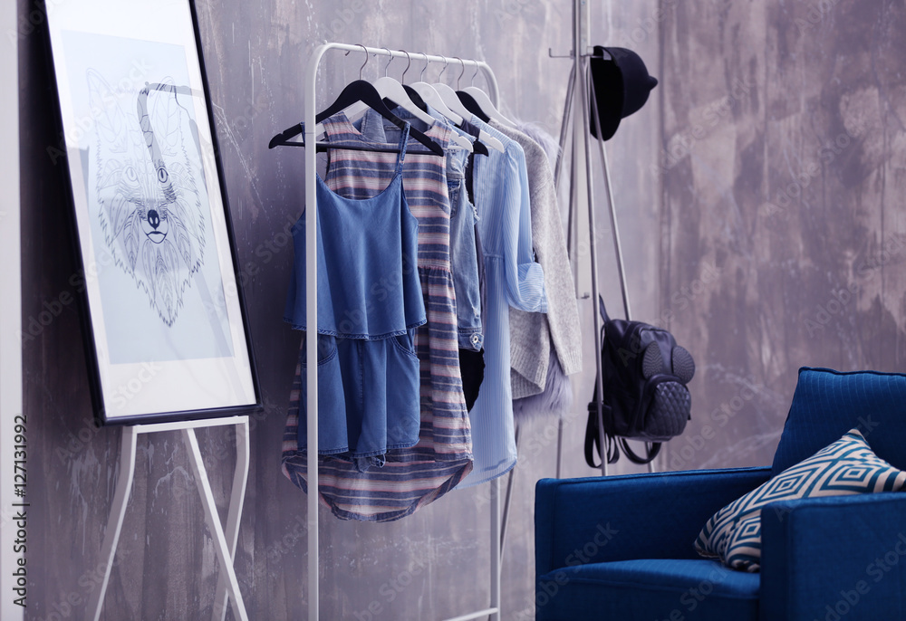 Fashionable clothes hanging on rack at modern dressing room