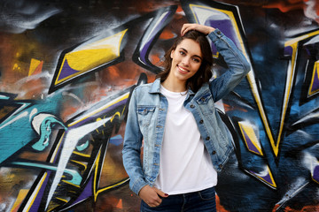 Sticker - Pretty young woman in blank t-shirt against graffiti wall