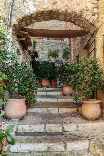 Fototapeta na wymiar Narrow street with flowers in the old town in France.