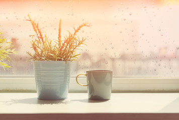 Coffee cup on table with rain drop  on window background,retro e