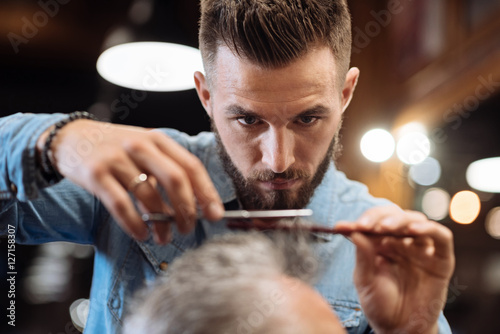 Fotografie, Obraz Close up of young male hairdresser cutting hair