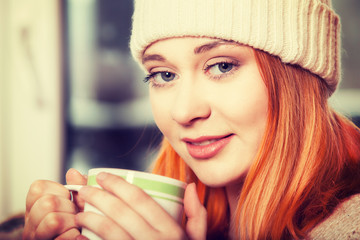 Woman wearing warm clothing and drinking hot drink