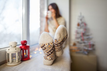 Young Beautiful Woman Relaxing On Window Sill In Christmas Decor