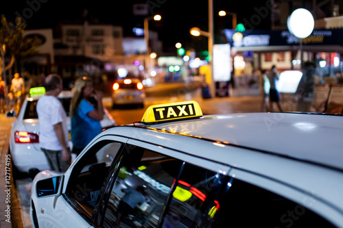 Plakat Taxi znak na dachu taxi przy nocą