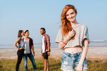 Sticker - Happy woman standing while her friends talking outdoors