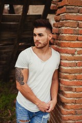 Wall Mural - Attractive guy next to a brick wall