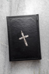 Closeup of  Christian cross on bible on the marble