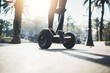 Young hipster girl driving on hoverboard at sunny park, active woman balancing on modern electric segway, alternative transport concept, ecology and environment concept, flare light