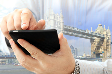 Poster - Close up of man using smartphone on London Tower Bridge background 