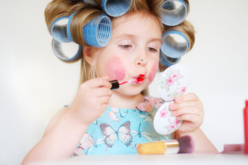 Adorable funny little girl making makeup with mother cosmetics