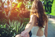 © Artem - Woman with beautiful hair discovering jungle holding boyfriend's hand.