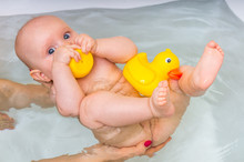 Newborn Baby Girl Bathing And Playing With Rubber Duck