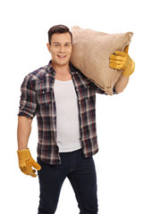 Canvas Print - Agricultural worker holding a burlap sack on his shoulder