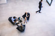 © Connect Images - High angle view of businesswoman and men meeting in office atrium