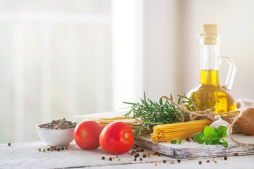 Healthy ingredients on a kitchen table - spaghetti, olive oil, t