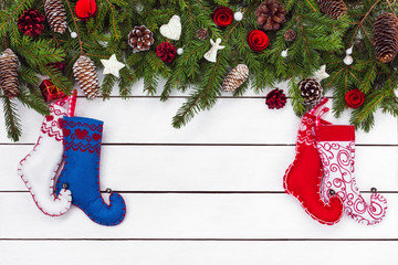 Christmas background. Colorful Christmas socks and fir tree on white wooden background. Top view, copy space