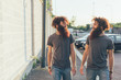 © Connect Images - Identical male adult twins strolling and chatting on sidewalk