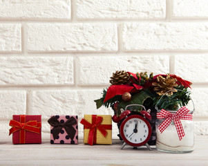 Wall Mural - Christmas decorations. Christmas background. Watch the candle and Christmas tree on a wooden table next to white wall.