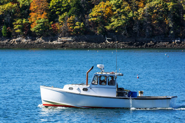 Lobster fishing boat in autumn against deep blue ocean water in coastal Maine, New England