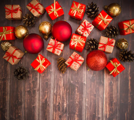 Christmas or New Year background: gifts, colored glass balls, decoration and cones on wooden background 