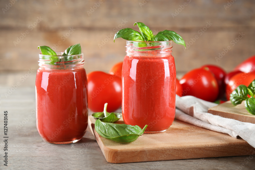 Glass jars with vegetable smoothie on wooden table