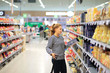 © lado2016 - Woman shopping in supermarket reading product information. Checking list.