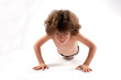 Curly boy in shorts pushed the floor. On the bent arms. White background.